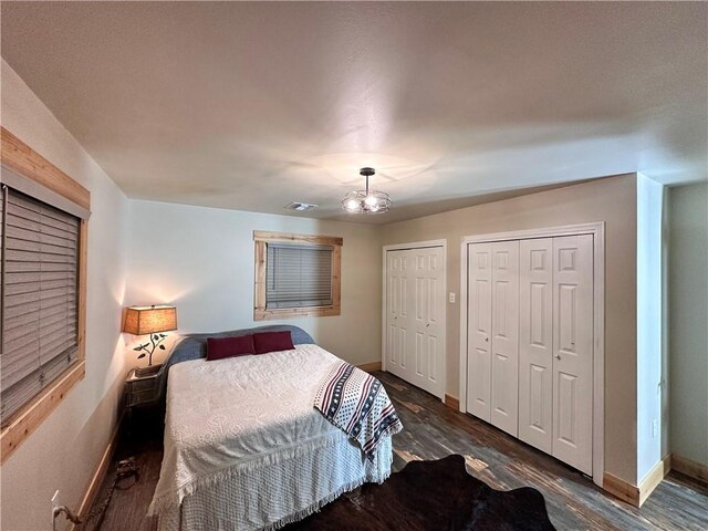 130 N Oak Ct, Luling, LA 70070 - bedroom with multiple closets, dark wood finished floors, and a chandelier