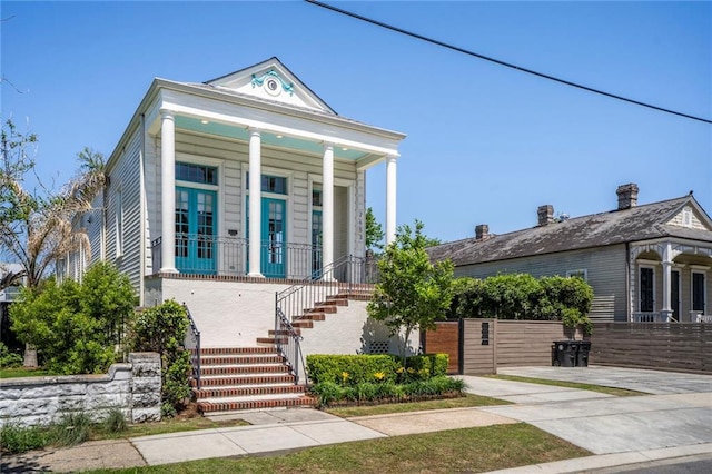 shotgun-style home with covered porch and stairway