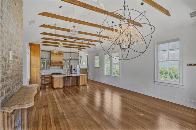 unfurnished living room with dark wood-type flooring, a wealth of natural light, and an inviting chandelier