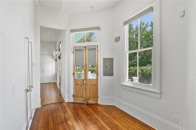 entryway with electric panel, hardwood / wood-style flooring, and baseboards
