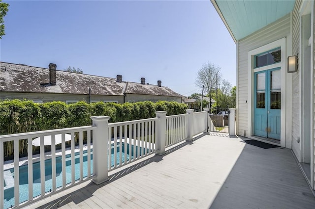 wooden deck with a fenced in pool