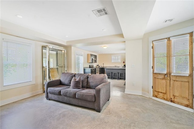 living room with visible vents, baseboards, and recessed lighting