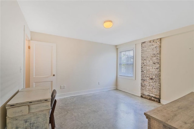 unfurnished office with finished concrete flooring and baseboards