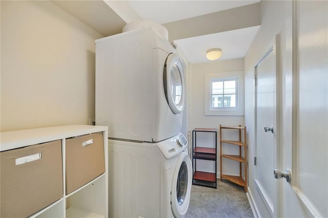 washroom featuring stacked washer / dryer and laundry area