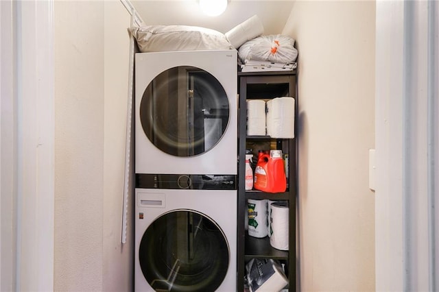laundry room featuring stacked washer / drying machine and laundry area