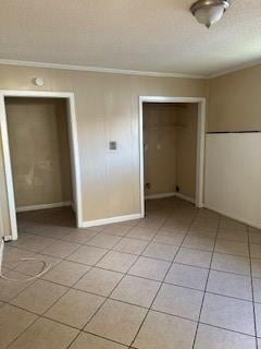 2829 Boyd St, New Orleans, LA 70131 - unfurnished bedroom with baseboards, a closet, light tile patterned floors, a textured ceiling, and crown molding