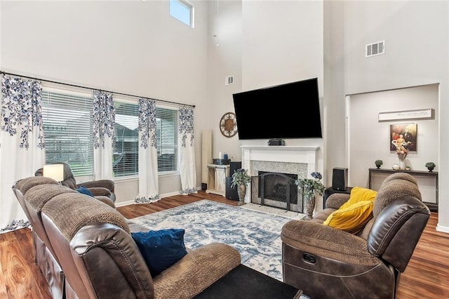 316 Providence Bay Rd, Slidell, LA 70461 - living area with visible vents, baseboards, a high ceiling, a fireplace, and wood finished floors