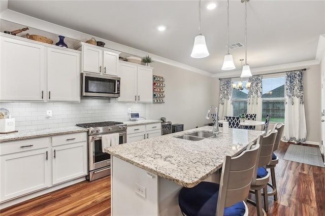 316 Providence Bay Rd, Slidell, LA 70461 - kitchen with dark wood-style flooring, ornamental molding, white cabinets, appliances with stainless steel finishes, and a sink