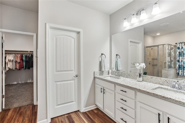 316 Providence Bay Rd, Slidell, LA 70461 - bathroom featuring a shower stall, wood finished floors, double vanity, and a sink