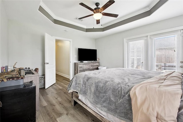 2925 Monica Ln, Marrero, LA 70072 - bedroom with baseboards, ornamental molding, visible vents, a tray ceiling, and wood finished floors