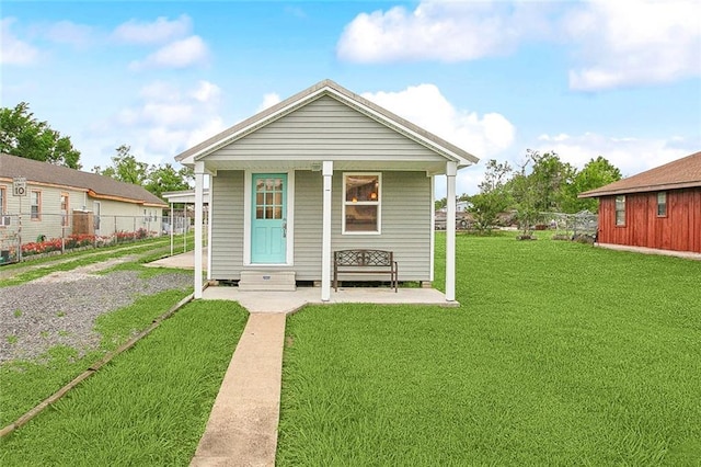 shotgun-style home with a front yard, entry steps, and fence