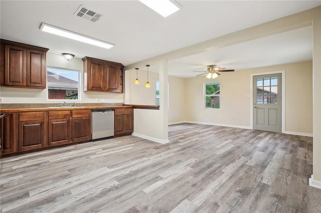 kitchen featuring visible vents, baseboards, dishwasher, a sink, and light wood-style floors