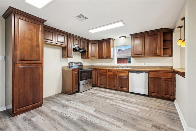 kitchen with light wood-type flooring, under cabinet range hood, visible vents, stainless steel appliances, and a sink