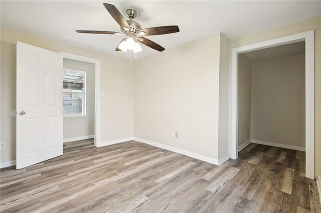 empty room featuring baseboards, a ceiling fan, and wood finished floors