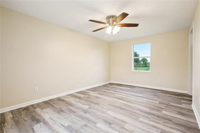 spare room with wood finished floors, baseboards, and a ceiling fan