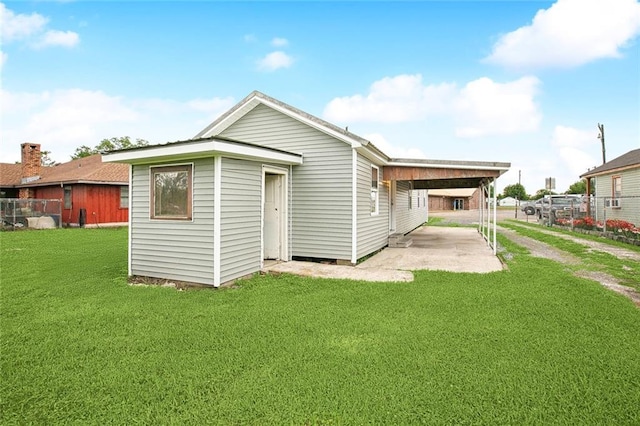 rear view of house featuring a yard and an attached carport