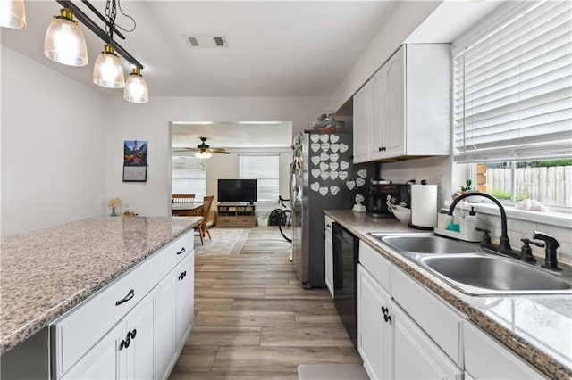 5387 Chamberlain Dr, New Orleans, LA 70122 - kitchen featuring visible vents, white cabinets, black dishwasher, a sink, and light wood-type flooring