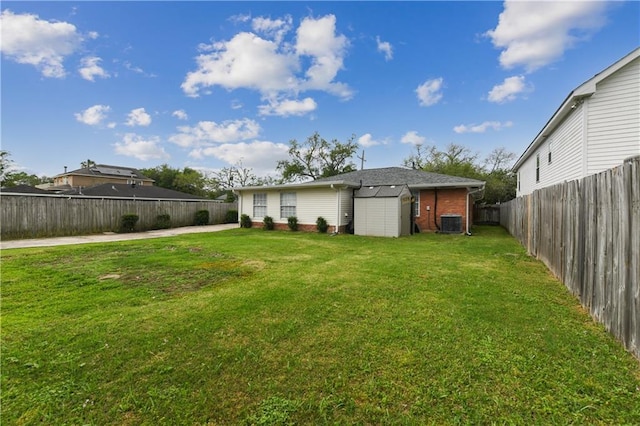 5387 Chamberlain Dr, New Orleans, LA 70122 - back of property featuring central air condition unit, a yard, a fenced backyard, and an outbuilding