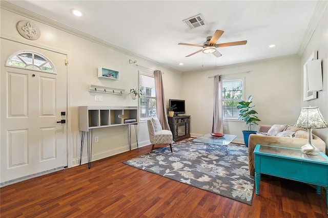 living room with ornamental molding, a ceiling fan, wood finished floors, and visible vents