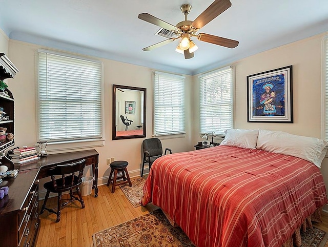 bedroom with light wood-type flooring, baseboards, and a ceiling fan