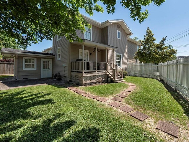 rear view of property featuring a yard, a fenced backyard, and ceiling fan