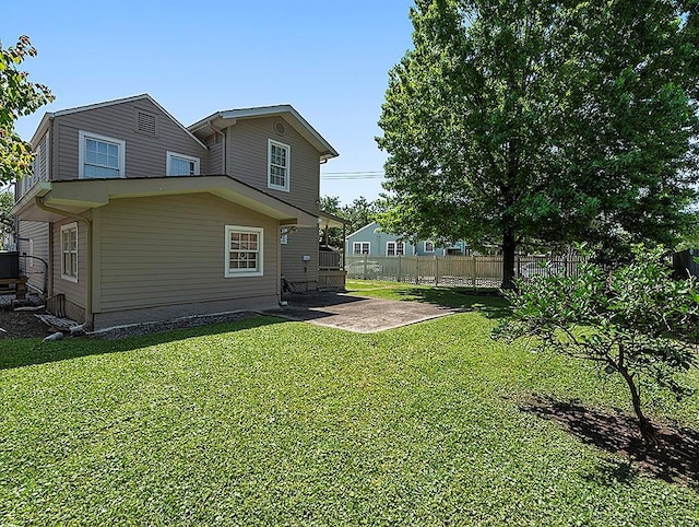 rear view of property with a patio area, fence, and a yard
