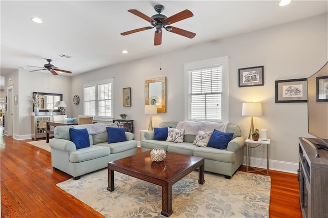 living room with visible vents, baseboards, a ceiling fan, and wood finished floors