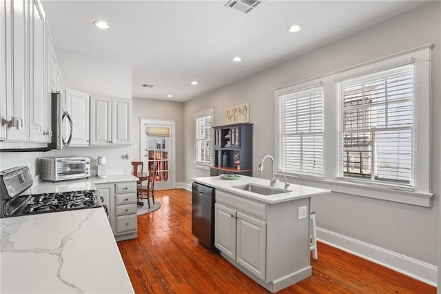 kitchen featuring baseboards, a toaster, dark wood-style floors, stainless steel appliances, and a sink