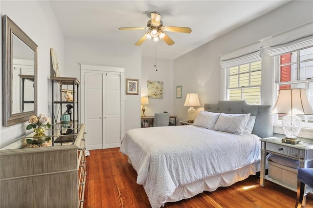 bedroom with dark wood-type flooring, a closet, and ceiling fan