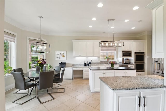 59 Spanish Fort Blvd, New Orleans, LA 70124 - kitchen featuring a healthy amount of sunlight, white cabinets, a center island, and appliances with stainless steel finishes