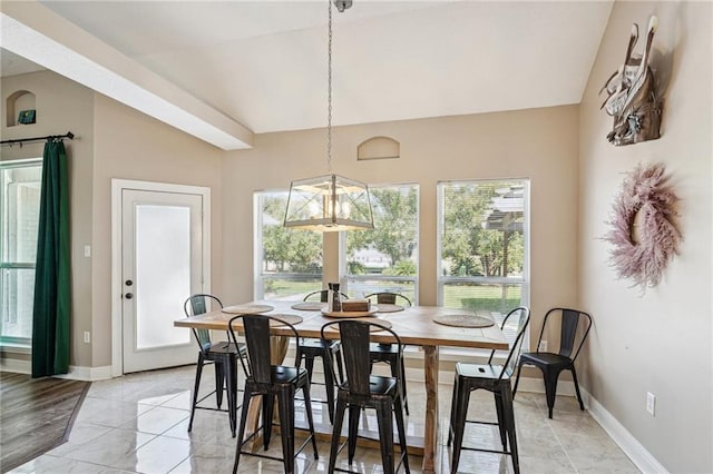 dining space with an inviting chandelier, baseboards, vaulted ceiling, and a healthy amount of sunlight