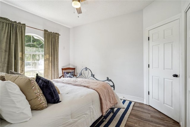 bedroom with baseboards, ceiling fan, and wood finished floors