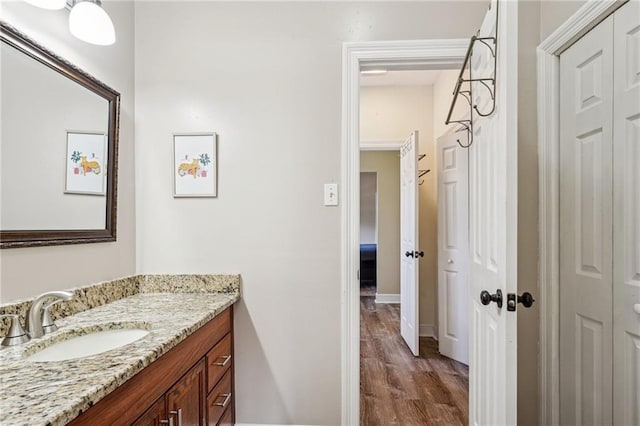 bathroom with vanity, baseboards, and wood finished floors