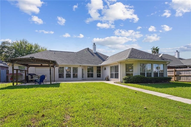 rear view of property with fence, roof with shingles, a chimney, an attached garage, and a yard
