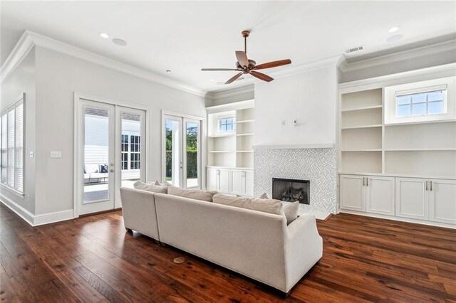 892 Chretien Point Ave, Covington, LA 70433 - living area featuring dark wood finished floors, crown molding, a ceiling fan, a fireplace, and built in shelves