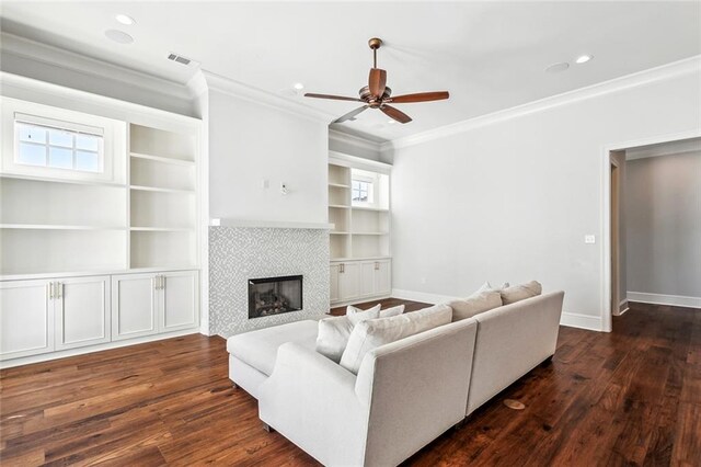 892 Chretien Point Ave, Covington, LA 70433 - living room with crown molding, a ceiling fan, a fireplace, dark wood-style flooring, and built in shelves