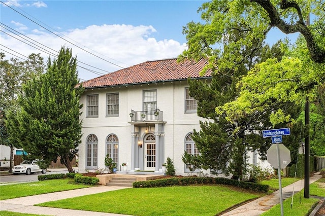 58 Fontainebleau Dr, New Orleans, LA 70125 - mediterranean / spanish home with a front lawn, stucco siding, a balcony, and a tile roof