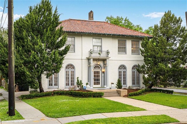 58 Fontainebleau Dr, New Orleans, LA 70125 - mediterranean / spanish-style house with a tiled roof, a chimney, stucco siding, and a front yard