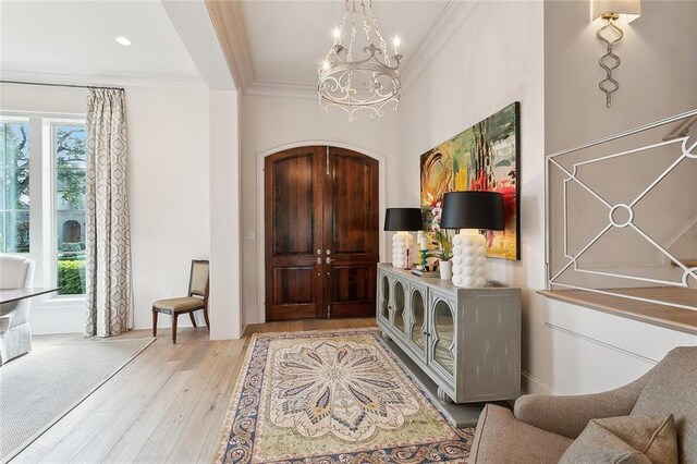 316 Sena Dr, Metairie, LA 70005 - foyer with arched walkways, an inviting chandelier, ornamental molding, and light wood-style flooring
