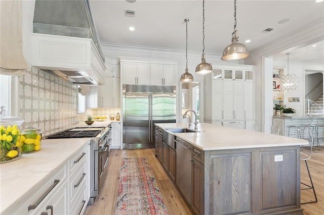 316 Sena Dr, Metairie, LA 70005 - kitchen with white cabinets, visible vents, a sink, crown molding, and high quality appliances
