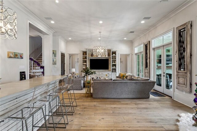 316 Sena Dr, Metairie, LA 70005 - living area with crown molding, light wood-style floors, french doors, a notable chandelier, and recessed lighting