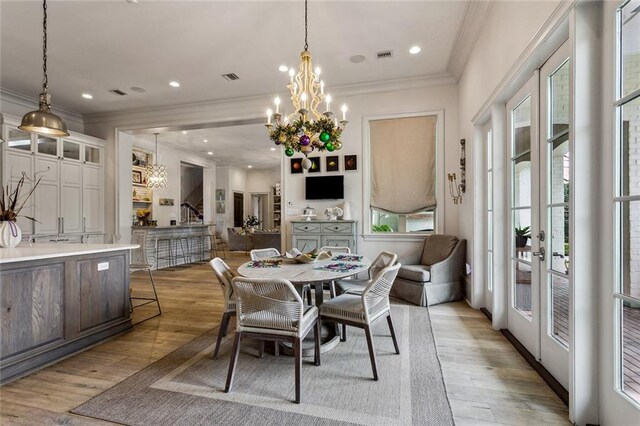 316 Sena Dr, Metairie, LA 70005 - dining space with light wood finished floors, crown molding, and an inviting chandelier