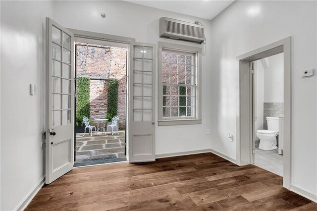 818 Bourbon St Unit 1B, New Orleans, LA 70116 - foyer with an AC wall unit and wood finished floors