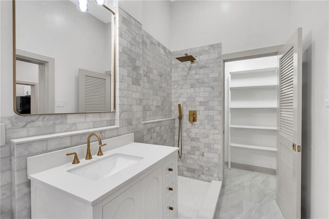 818 Bourbon St Unit 1B, New Orleans, LA 70116 - full bathroom with a stall shower, vanity, marble look tile flooring, and tile walls