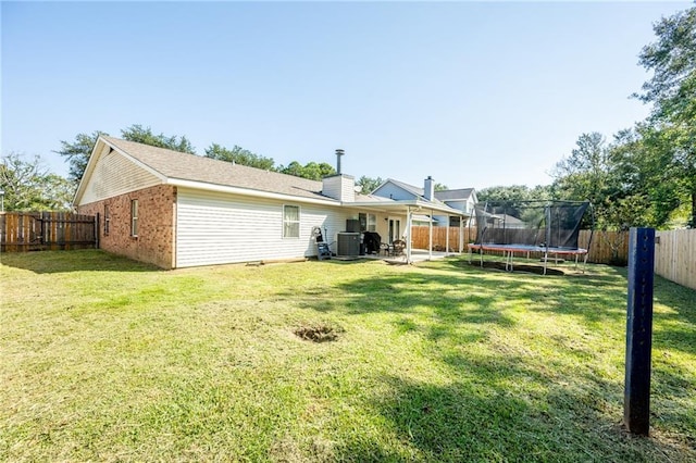 1025 Breckenridge Dr, Slidell, LA 70461 - back of property with a trampoline, a fenced backyard, a patio, and brick siding