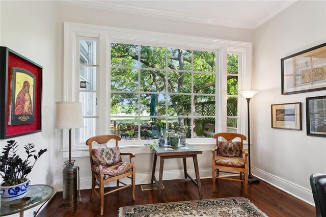 sitting room featuring wood finished floors, crown molding, and baseboards