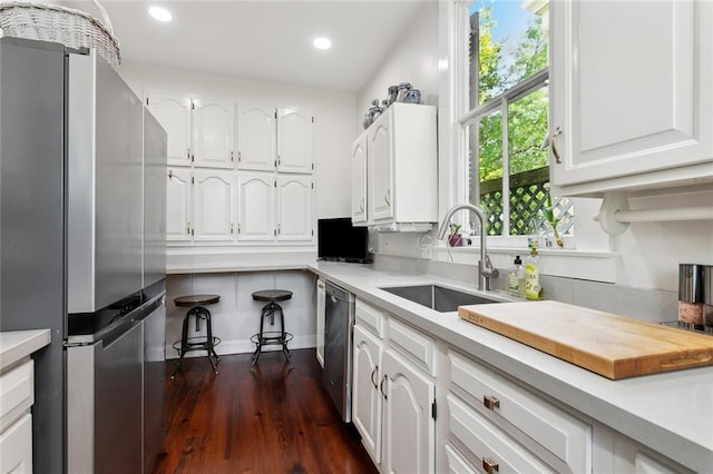 kitchen featuring appliances with stainless steel finishes, a sink, white cabinetry, light countertops, and recessed lighting