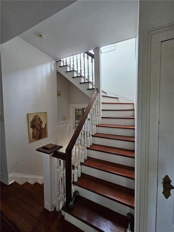 stairway with wood finished floors and baseboards