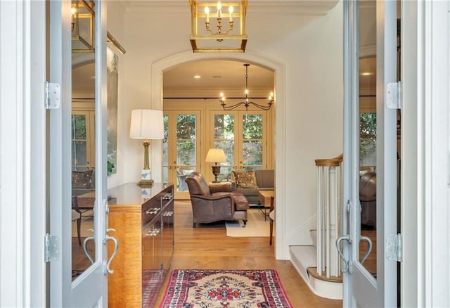 225 Ridgewood Dr, Metairie, LA 70005 - interior space with arched walkways, french doors, light wood finished floors, and ornamental molding