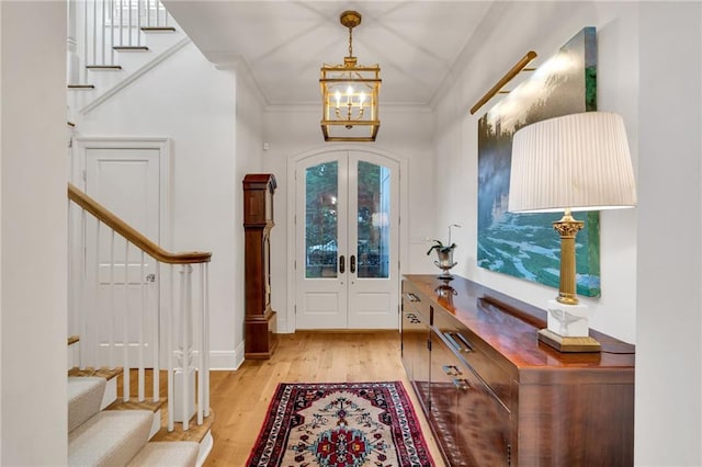 225 Ridgewood Dr, Metairie, LA 70005 - foyer featuring an inviting chandelier, light wood-type flooring, ornamental molding, stairway, and french doors